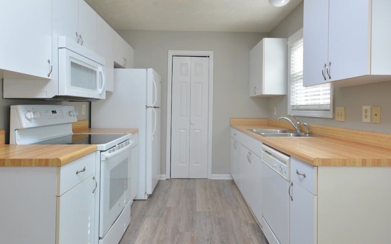 kitchen on wood-style flooring, with modern appliances and easy to access hallway